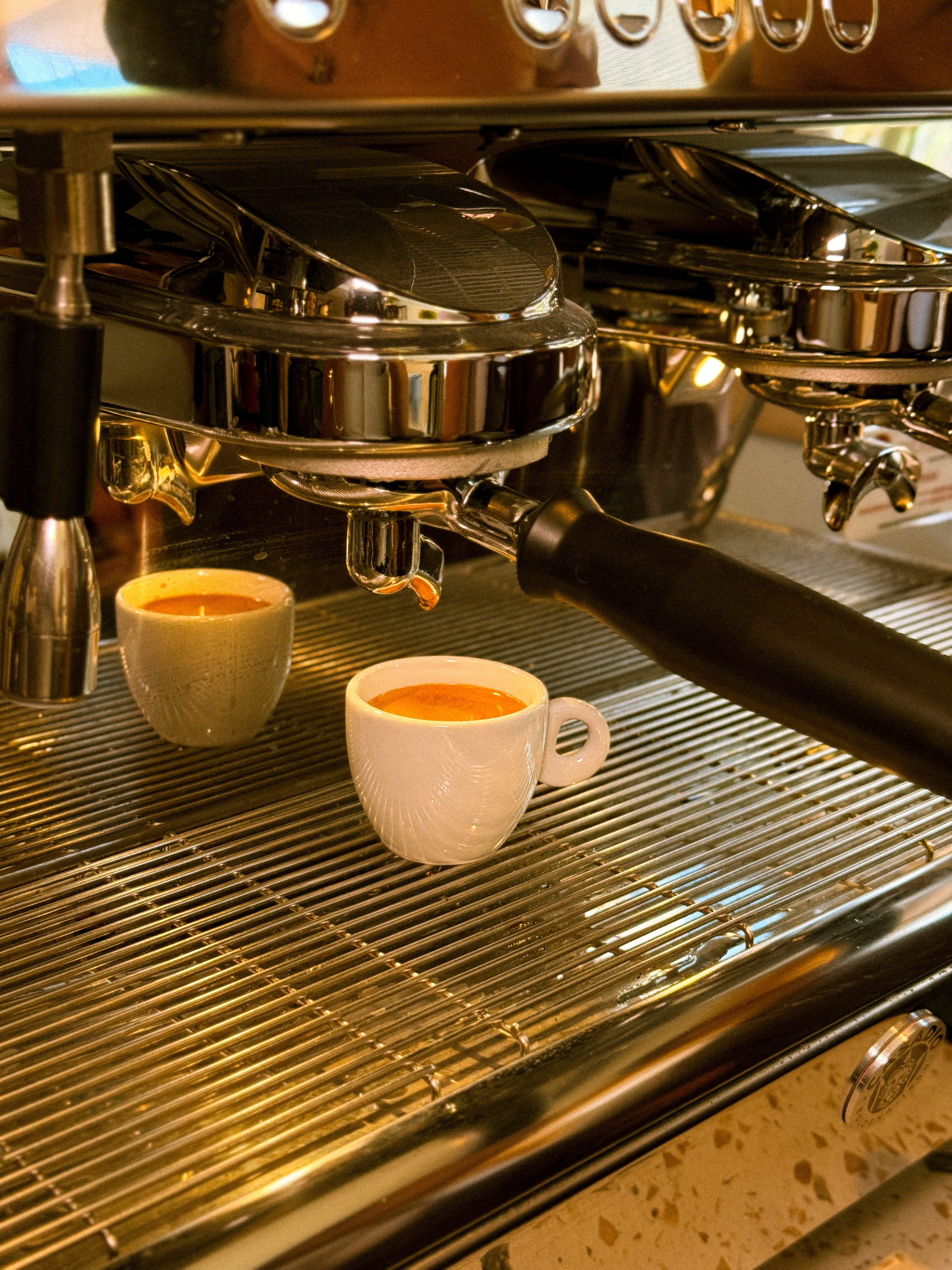 Xícaras de espresso sendo preparadas na máquina do Zóca